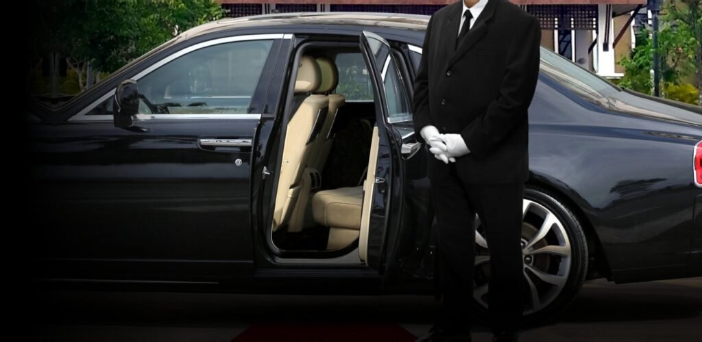 Chauffeur standing by luxury black car with open door – United Limo INC premium airport limo service.