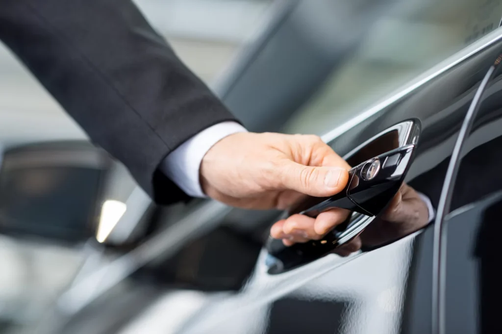 Close-up of a United Limo INC chauffeur opening the door of a luxury vehicle in New York.